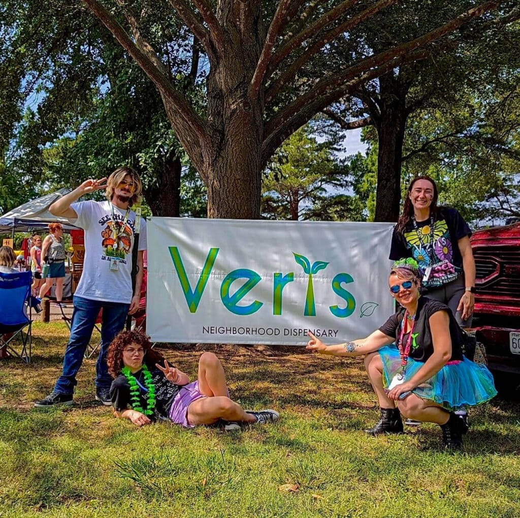 Verts Dispensary Team with Banner at Community Even Verts Dispensary team posing with their banner at a community event